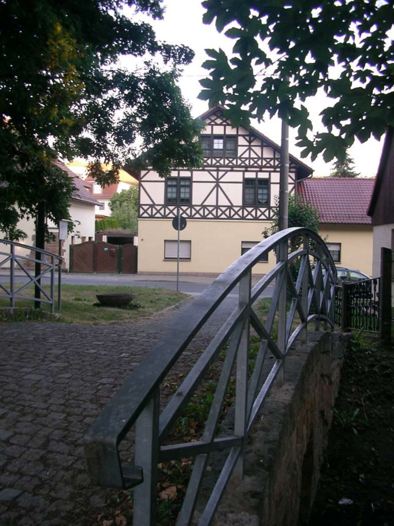 Brücke über den Hungerbach. Im Hintergrund das Kutscherhaus des ehemaligen Gutes
